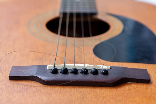 Close up of brown guitar with torn string