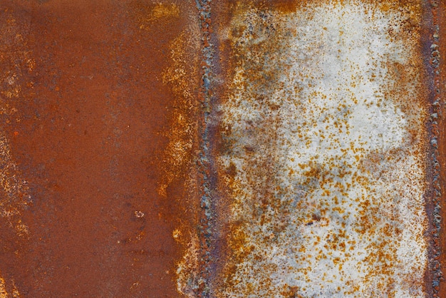 Photo close up of a brownish rusted welded sheet metal surface with yellowish and orange hue