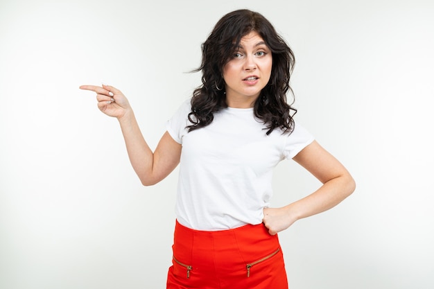 Close-up of a brunette girl in a white T-shirt with holding hands on a white studio background