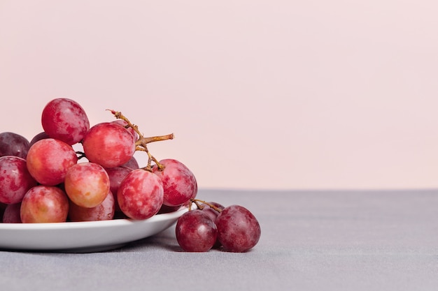 Close-up of a bunch of grapes on a pink background