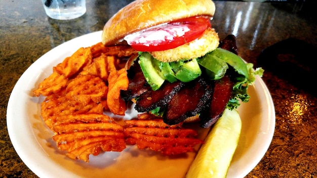 Close-up of burger and chips in plate on table