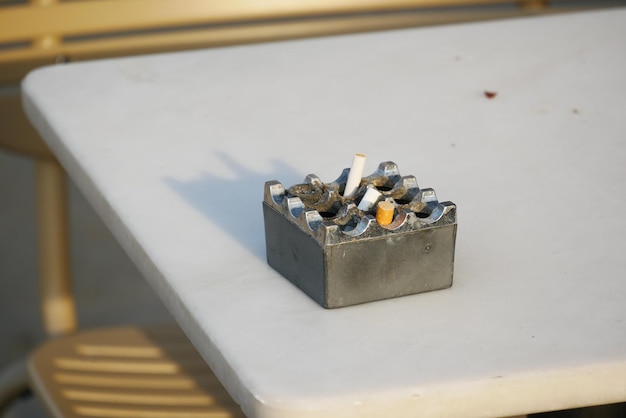 Close up burning cigarette in ashtray on table