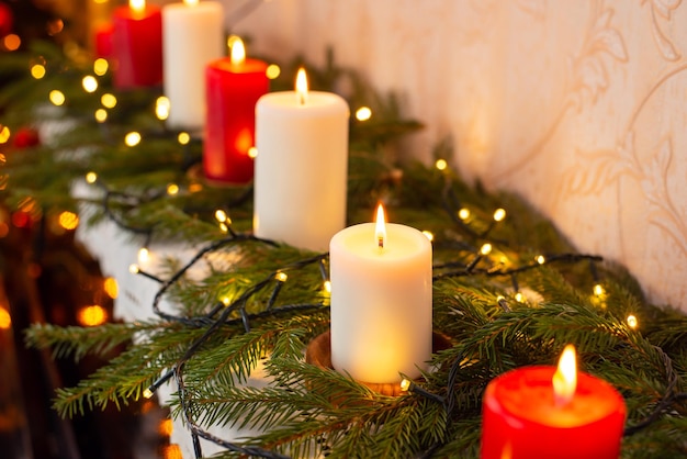 Close up of burning red and white candles on the piano Christmas decorations at home festive atmosphere