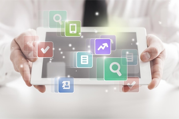 Close-up of business man holding digital tablet with signs on office background