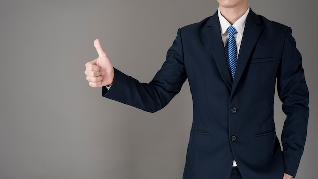 Close up Business man is thumbs up, grey background in studio 