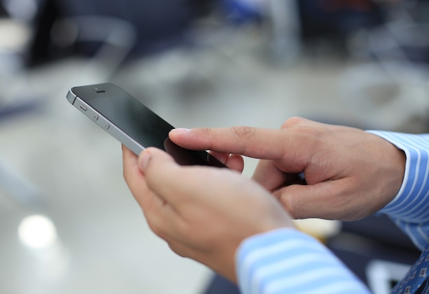 Close up of a business man using mobile smart phone