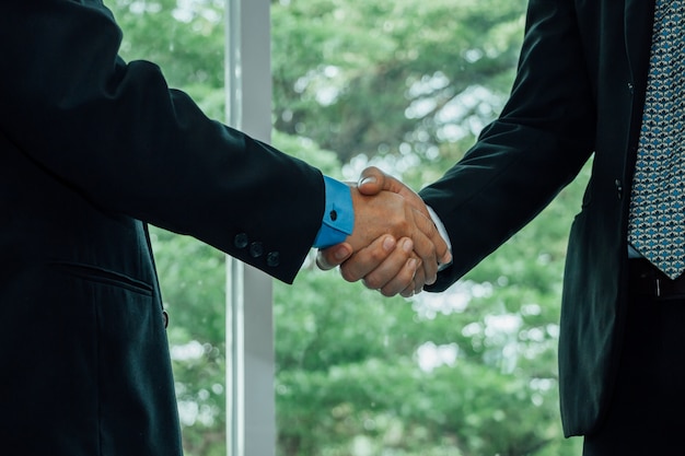 Close up business men shaking hand when deal project done