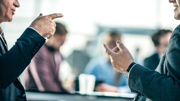 Close up . business partners argue sitting at the office table. photo with a copy-space