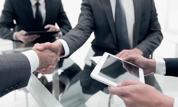 Close up business people handshake over the desk