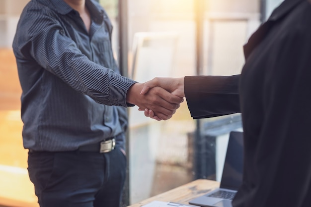 Close-up of business people shaking hand meeting success at the office.