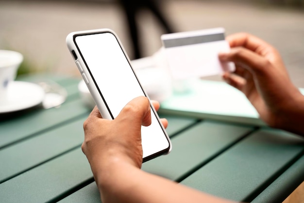 Close up of business woman hand holding credit card using mobile phone shopping