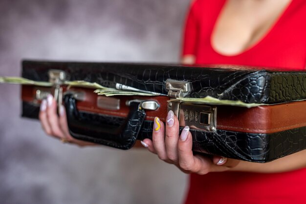 Close up business woman hold black case full of money