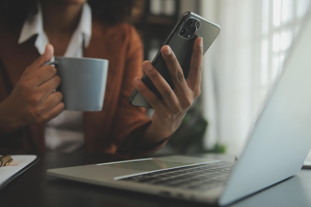 Close up Business woman using calculator and laptop for do math finance on wooden desk tax accounting statistics and analytical research concept