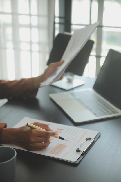 Close up Business woman using calculator and laptop for do math finance on wooden desk tax accounting statistics and analytical research concept