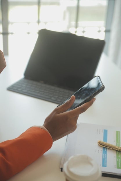 Close up Business woman using calculator and laptop for do math finance on wooden desk tax accounting statistics and analytical research concept