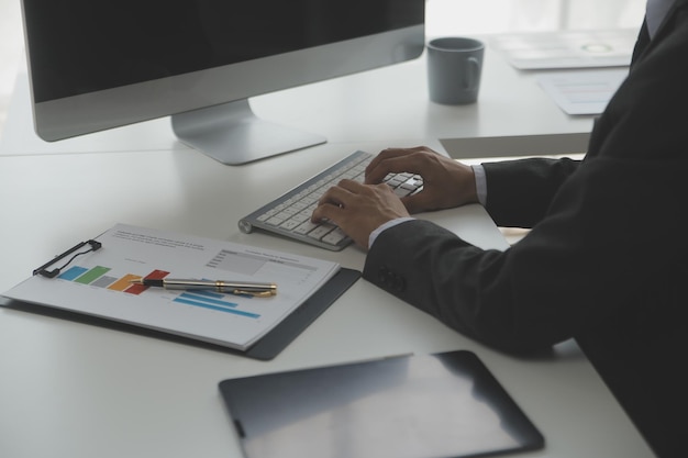 Close up Business woman using calculator and laptop for do math finance on wooden desk tax accounting statistics and analytical research concept