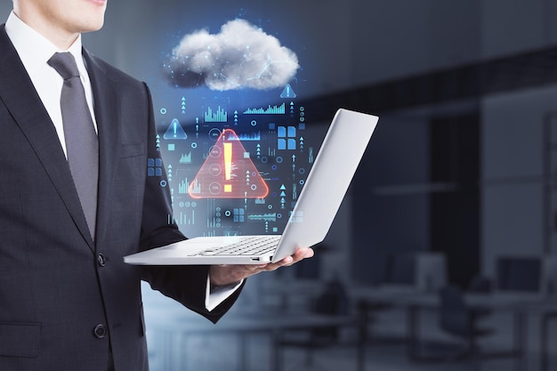 Photo close up of businessman hand holding laptop in blurry office interior with abstract hologram raining cloud data information leak security and theft concept double exposure