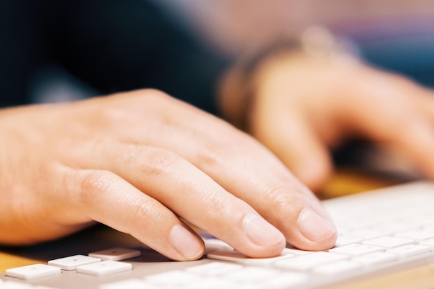 Photo close up of businessman hands typing on white computer keyboard blurry background technology and communication concept