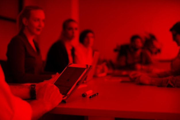 close up of  businessman hands  using tablet, people group in office meeting  room blurred in backgronud