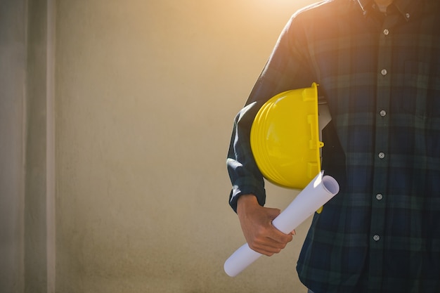 Close up Businessman holding yellow hard hat builder construction estate