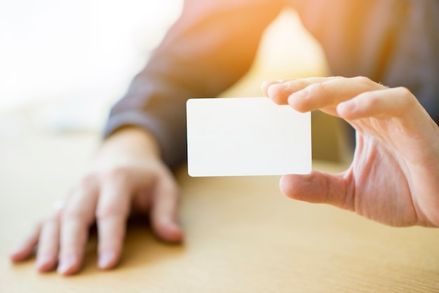 Close-up of a businessman's hand holding blank white card