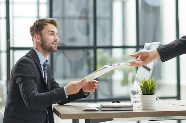 Close Up Of Businessman Taking Folders From Hand