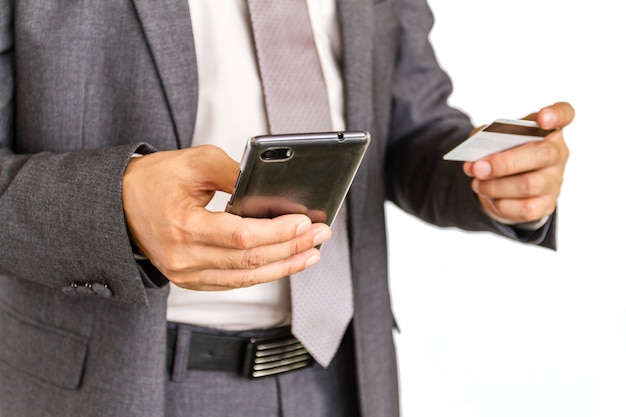 Close up of businessman using smart phone and holding credit card 