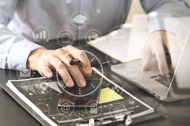 Close up of businessman working with smart phone and digital tablet and laptop computer