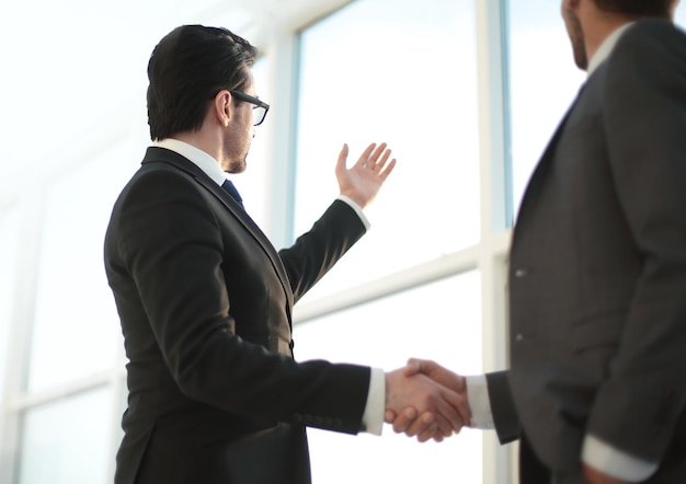 Close up businessmen shaking hands during a conversation in the office the concept of cooperation