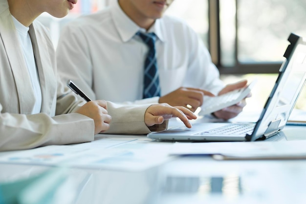 Close up businesspeople are working by discuss and analyses their project by using laptop and graphs