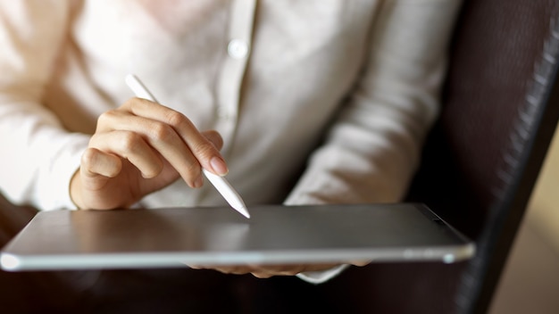 Close up of businesswoman hand working on tablet with stylus, suite for business or study content