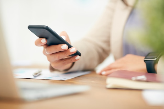 Close Up Businesswoman Holding Smartphone at Desk