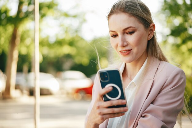 Close up of a businesswoman using smartphone outdoors in the city