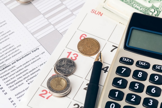 Close up of a calculator and coins on a business