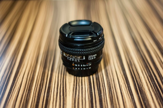 Photo close-up of camera lens on wooden table