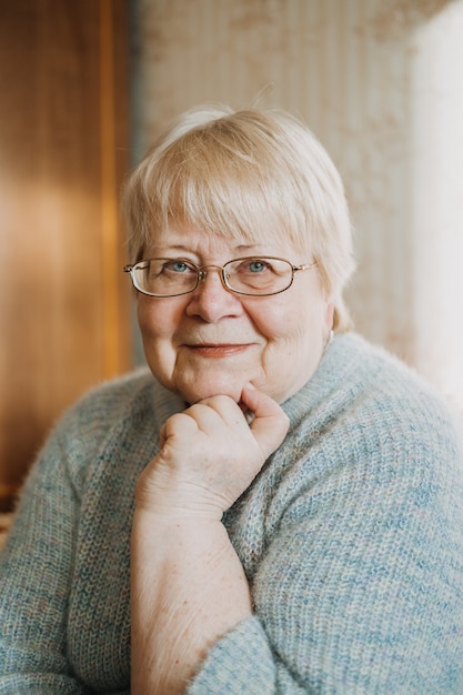 Photo close up candid, authentic portrait of senior plus size blonde woman at home. portrait of mature woman with eyeglasses.