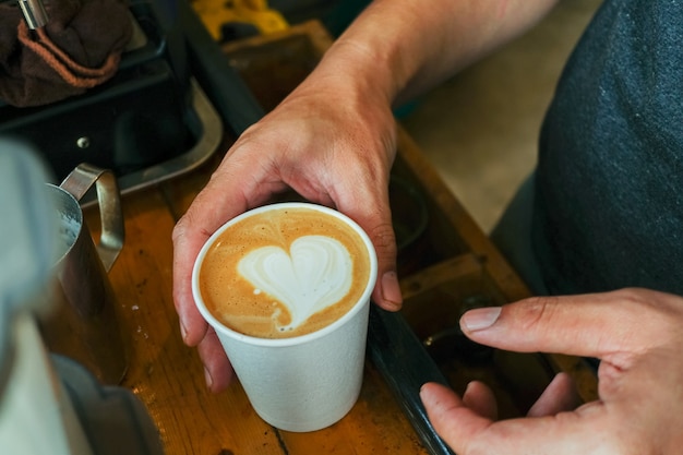 close up cappuccino with latte art on wood table 