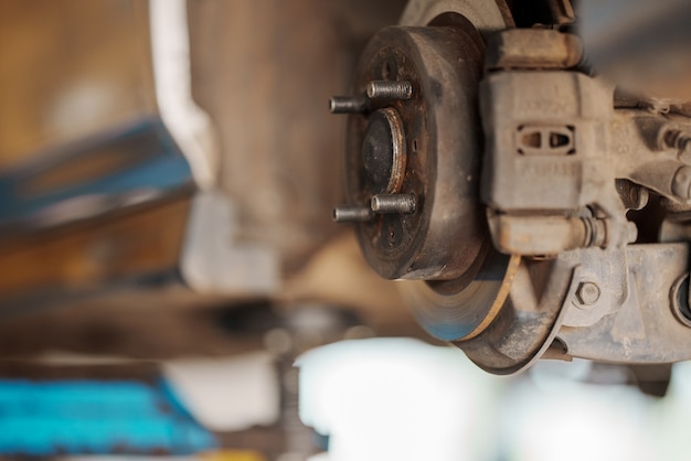 Close up Car mechanic replace tire on wheel in auto repair service workshop.