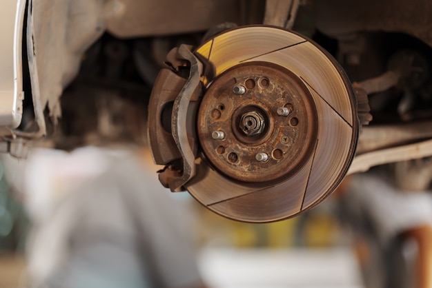 Close up Car mechanic replace tire on wheel in auto repair service workshop.