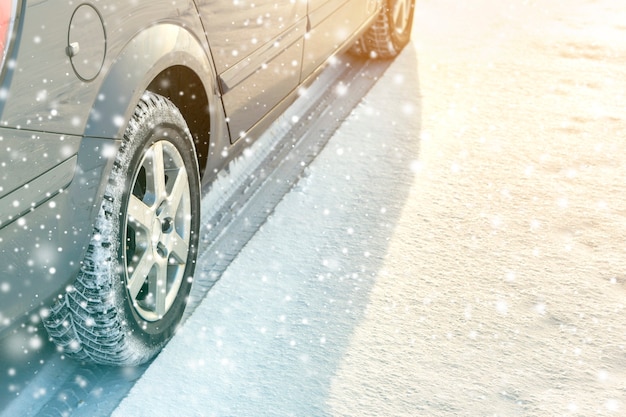 Close-up of car wheels rubber tires in deep winter snow. Transportation and safety concept.