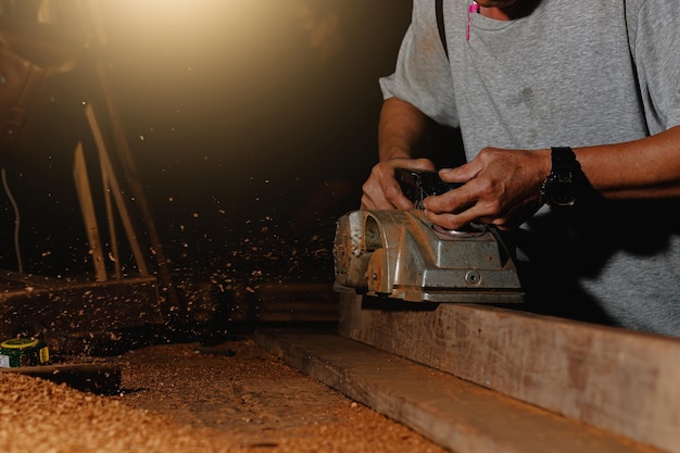 Close-up of a carpenter using a circular saw or a tool to cut wooden planks To make furniture in homes and residences, hotels, rooms made of wood.