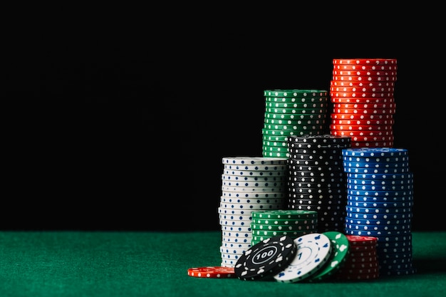 Close-up of casino chips stack on green poker table