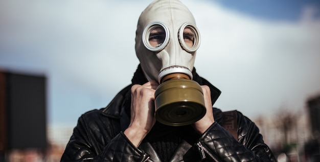 Close up. casual guy in a gas mask on a city background . photo with a copy-space