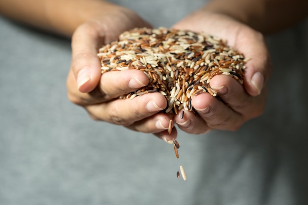 Close up cereal rice grains falling from woman's hand 