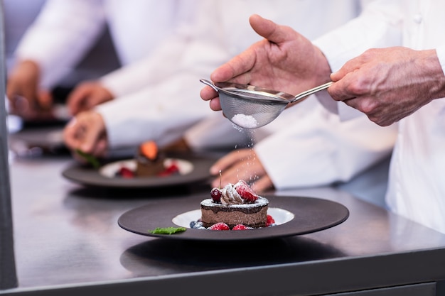 Close-up of chef finishing a dessert plate