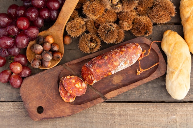 Close up chestnuts chorizo and grapes on rustic wooden table