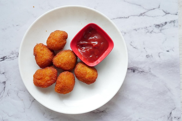 Close up of chicken nugget and sauce on table