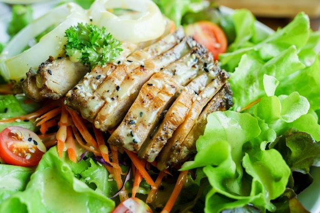 Close up of chicken salad with tomatoes, onions and lettuce.