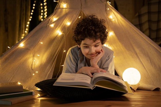 Close up on child reading in his house tent