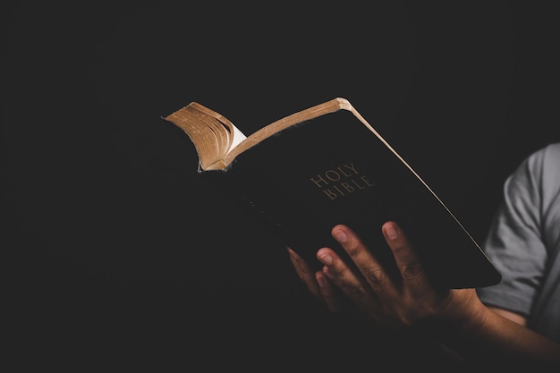 Close up of christian woman hand holding holy bible pray and worship for thank god in church